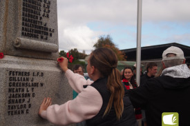 Residents place poppies at the service.