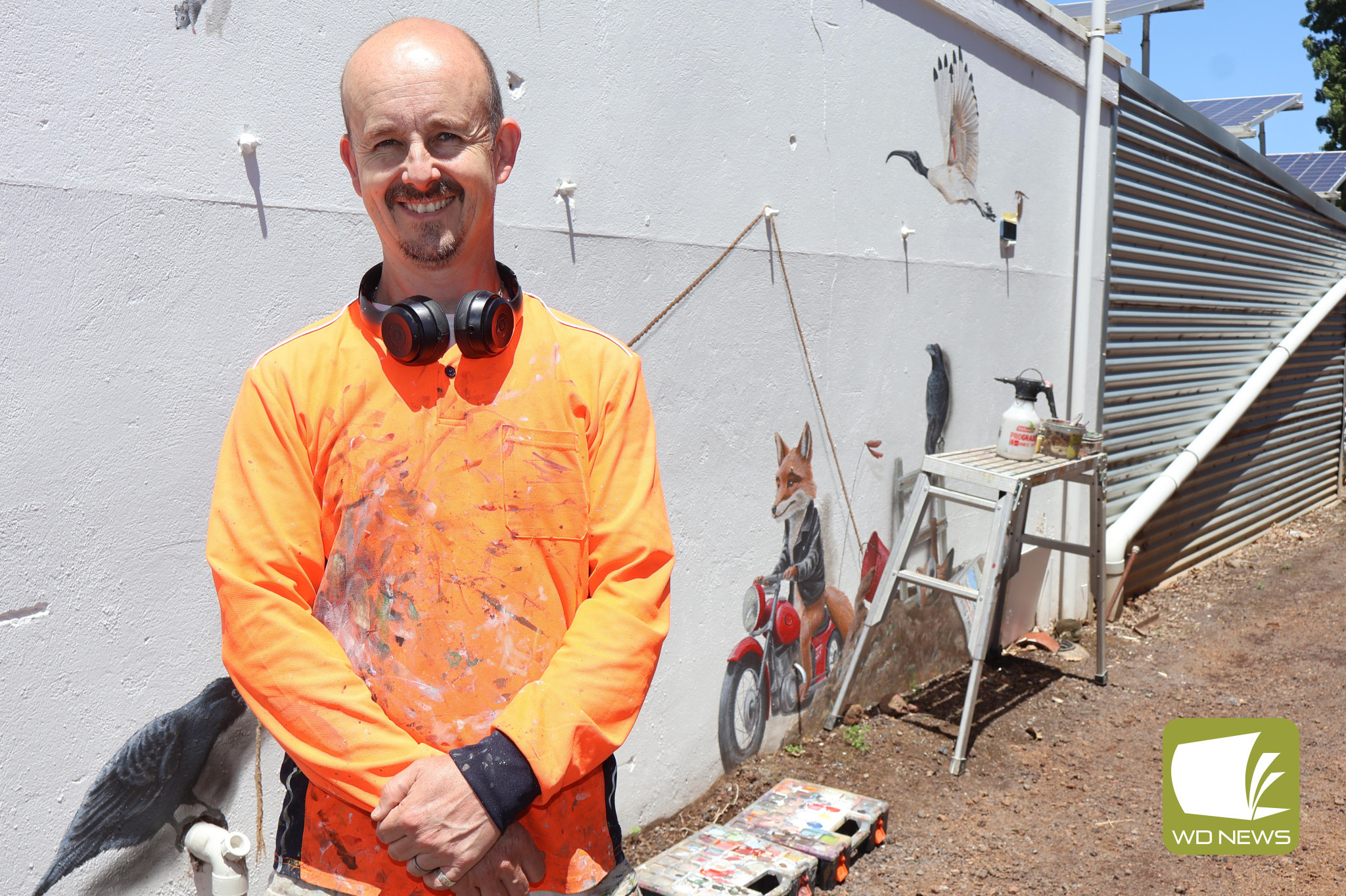 What’s going on?: Jimmi Buscombe is rapt with the positive reception the mural at the Mortlake Roadhouse is receiving as the story he is painting begins to unfold.