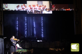 Reflecting on history: Violinist Laura Flanagan played as images of previous Carols events were shown to mark 75 years of the community event.