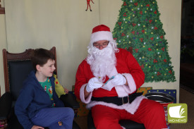 Sweet moment: Darcy Gee handed Santa Claus a Christmas card during his photo session on Sunday.