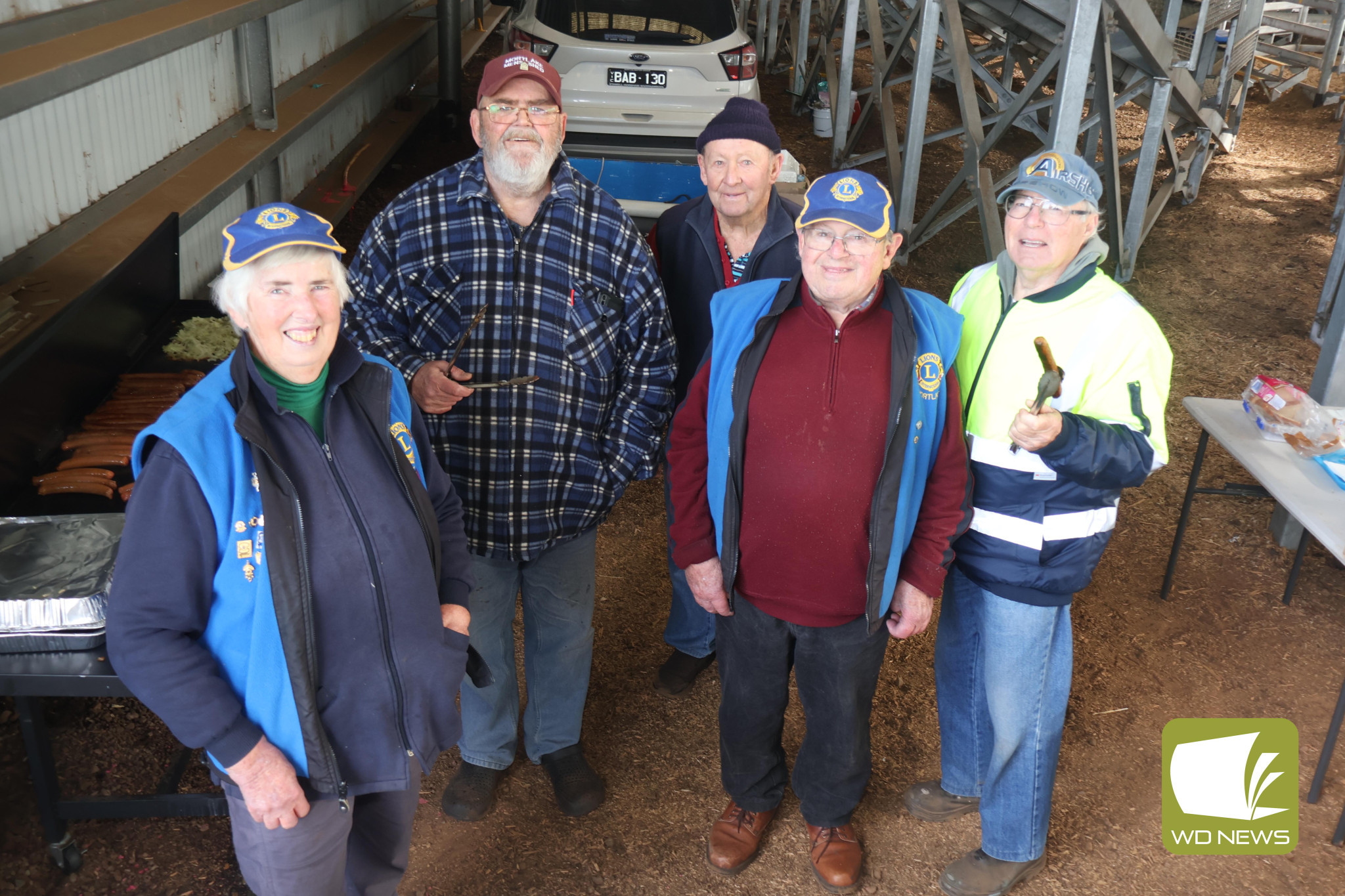 Feeding the masses: Members of the Mortlake Lions were happy to man a free barbecue to support farmers at the Western Victoria Livestock Exchange last week.