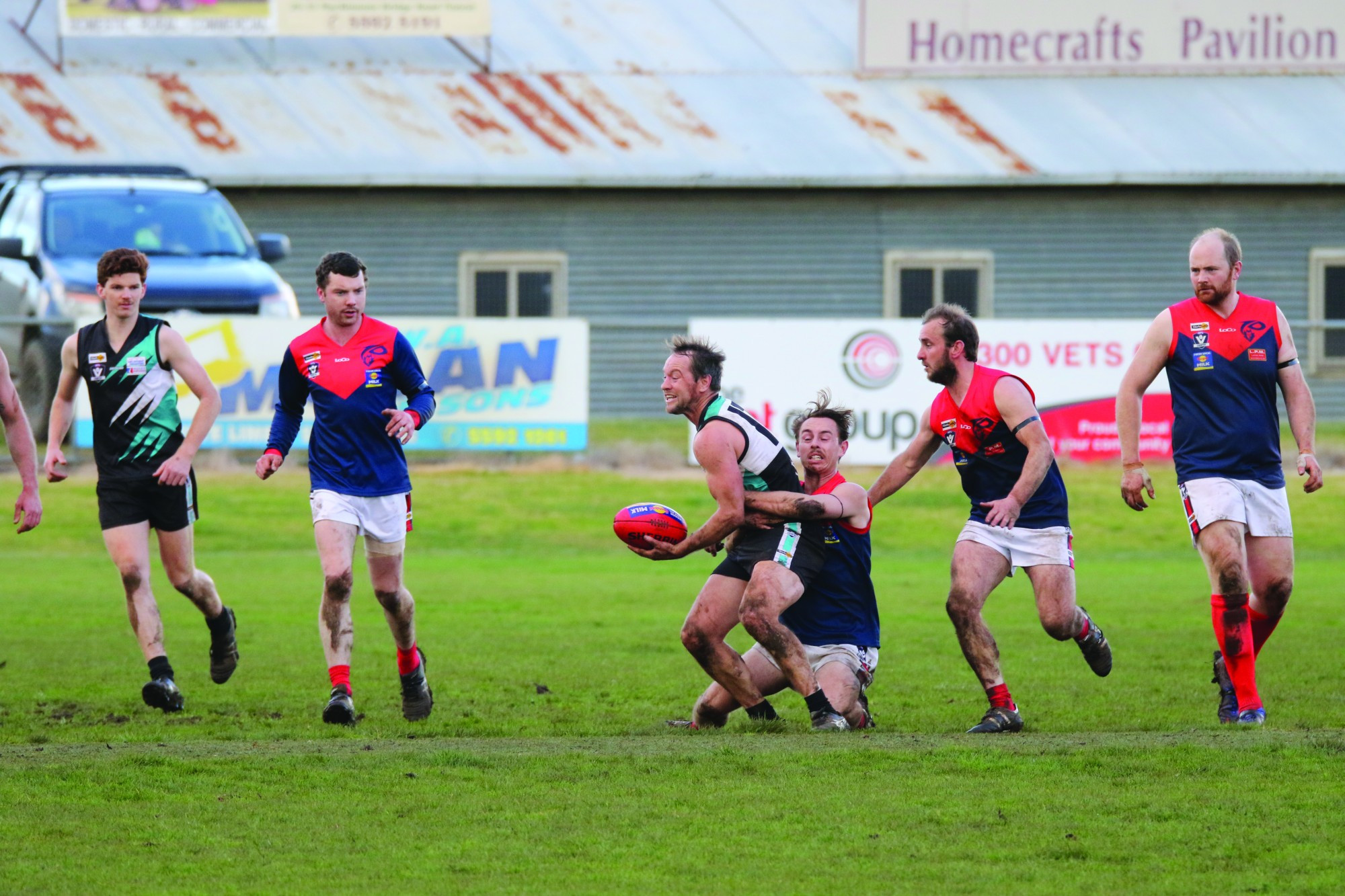 Timboon’s Ben Bacon, backed by team-mate Ash Hunt, puts a hard tackle on Kolora Noorat’s Joel Moloney.