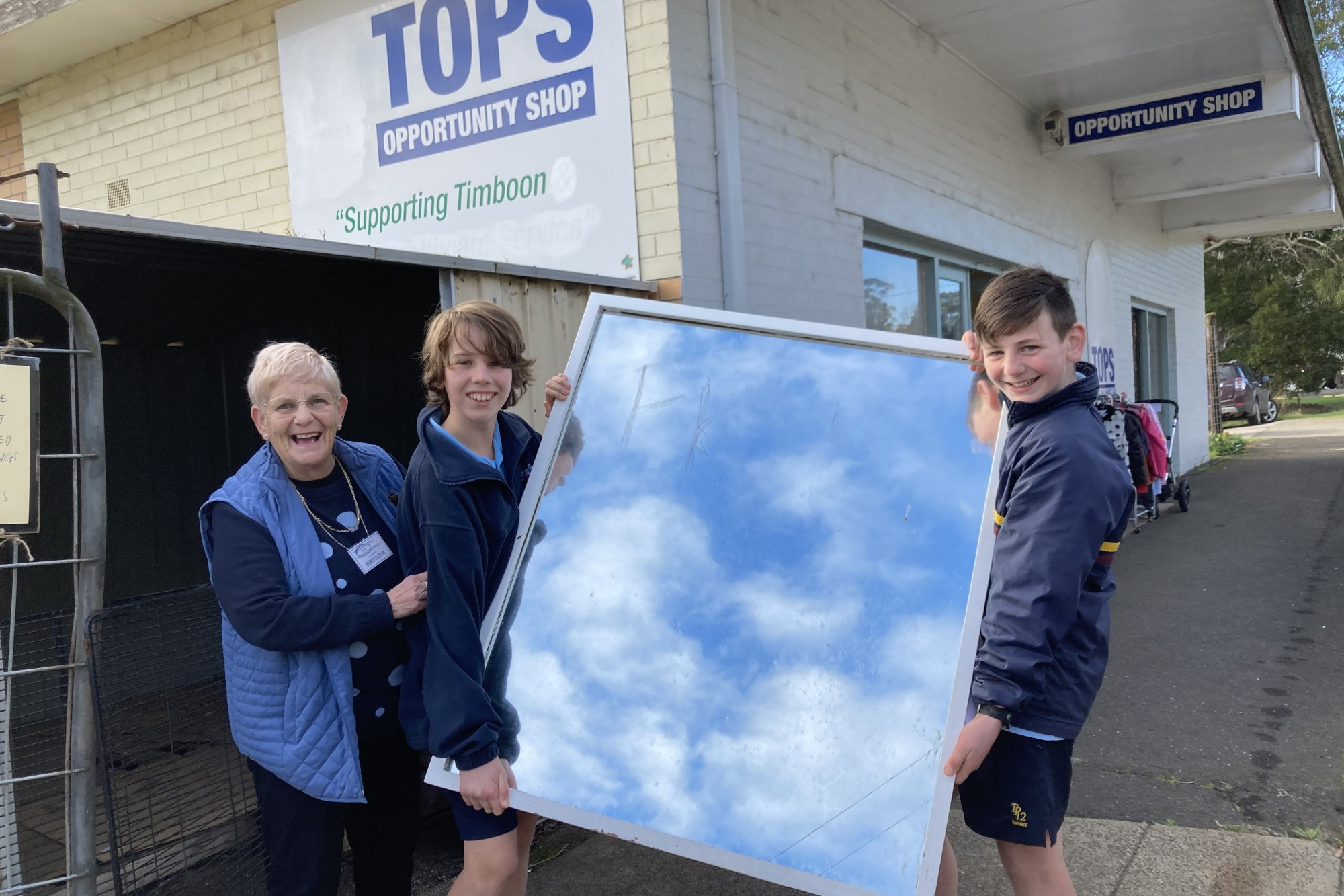 Learning experience: Timboon P-12 School students Jhyce Bartlett and Jalen Berry help out TOPS co-ordinator Brenda Parfett during a class visit to the popular op shop.