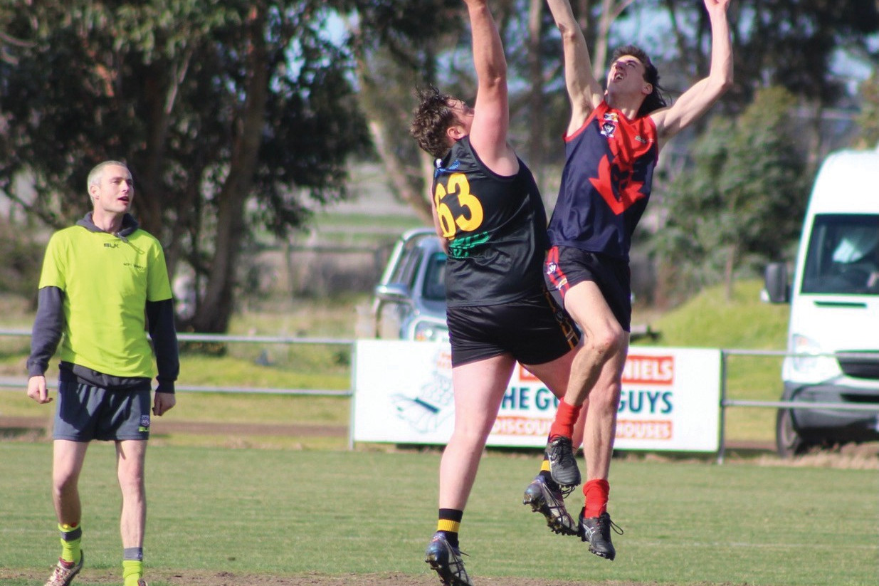 The Demon’s Jayden Brewer flies over Tiger Geordie MacDonald. Photos courtesy Larnie Loader.