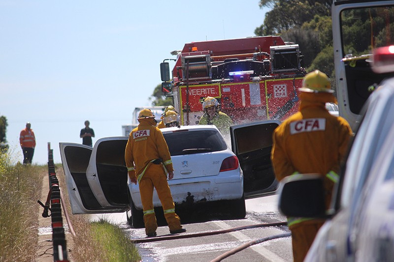 Local Country Fire Authority volunteers work to extinguish a car fire on the Princes Highway at Weerite yesterday (Monday).