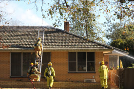 Working together: CFA volunteers donned breathing apparatuses to help put out the fire in the roof cavity. 