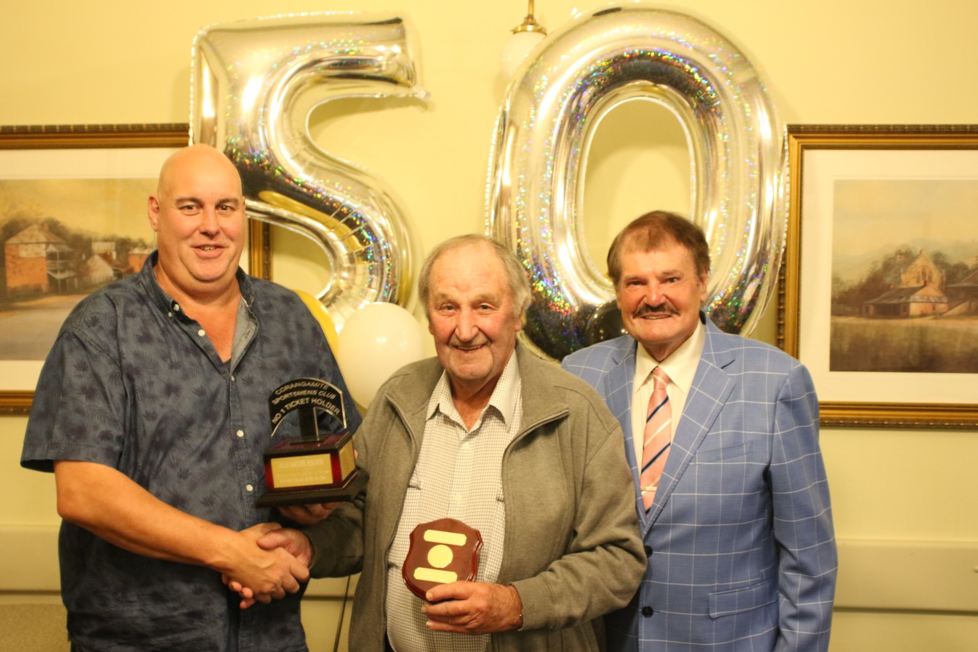 Brian Boyd (centre) is presented the Alan McKenzie Memorial trophy by Rick McKenzie (left) and Sportsmen’s Club president Ron Cameron.