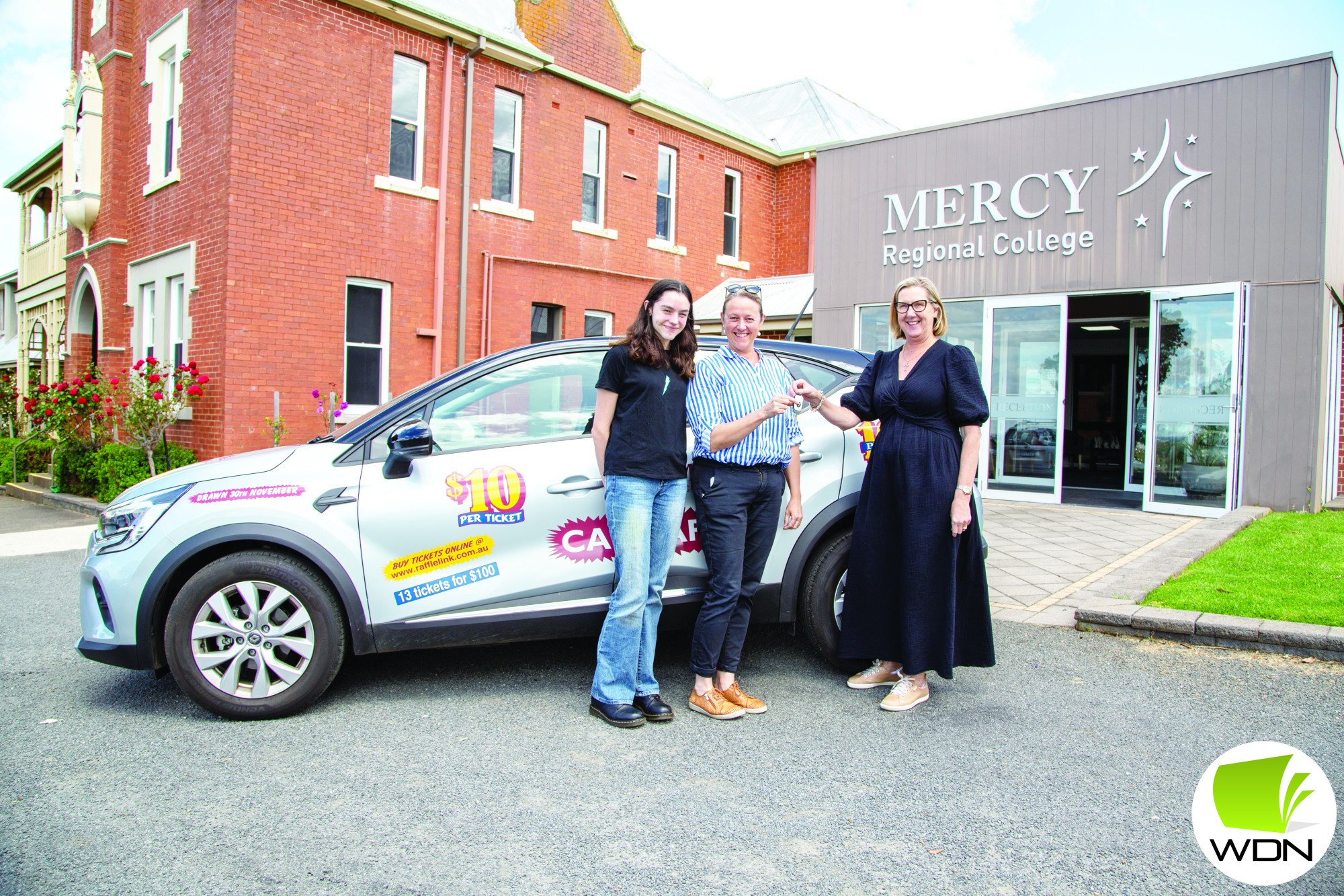 Car winner: MRC principal Sharon Gillett passes the car keys to the annual car raffle winners Rachel and Matilda Kealley.