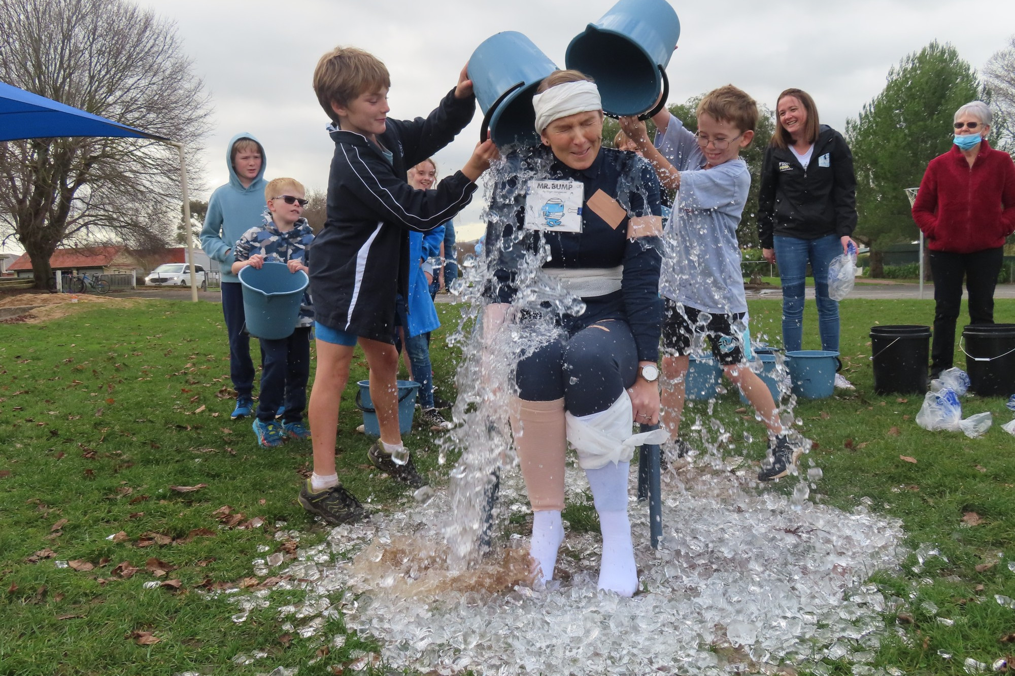 School initiative: Camperdown College junior campus students Josh Burgess and Blake Evans dump a bucket of ice cold water over assistant principal Jacinta Tolland.