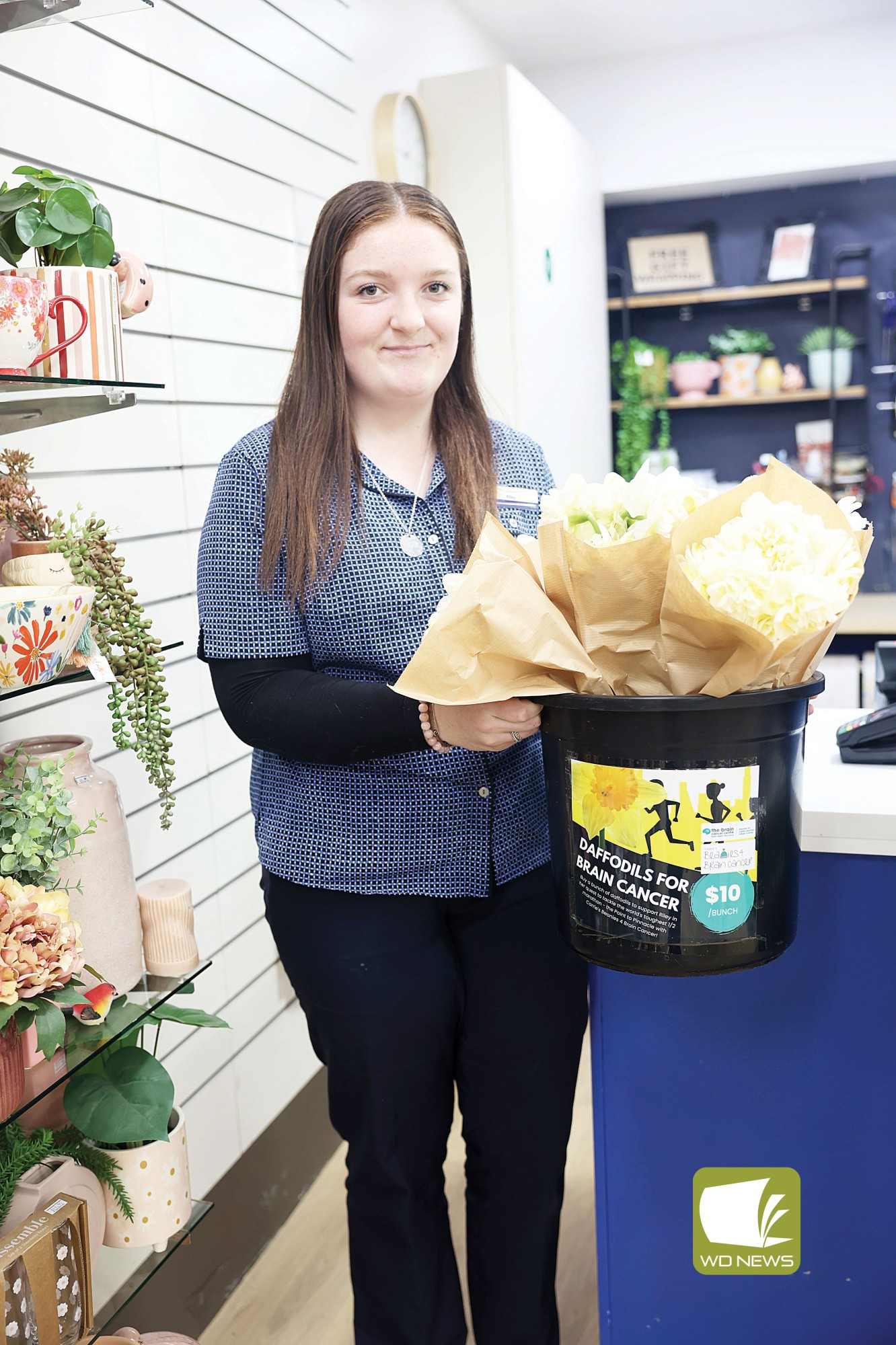 Fundraising flowers: Pharmacy assistant Riley Stephenson has been selling daffodils as she prepares for the Point to Pinnacle half marathon.