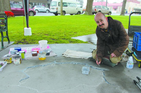 Eye-popping art: Renowned 3-D artist Jimmi Buscombe worked through the rain and wind on a new piece on a section of the Terang avenue’s pavement during the day.