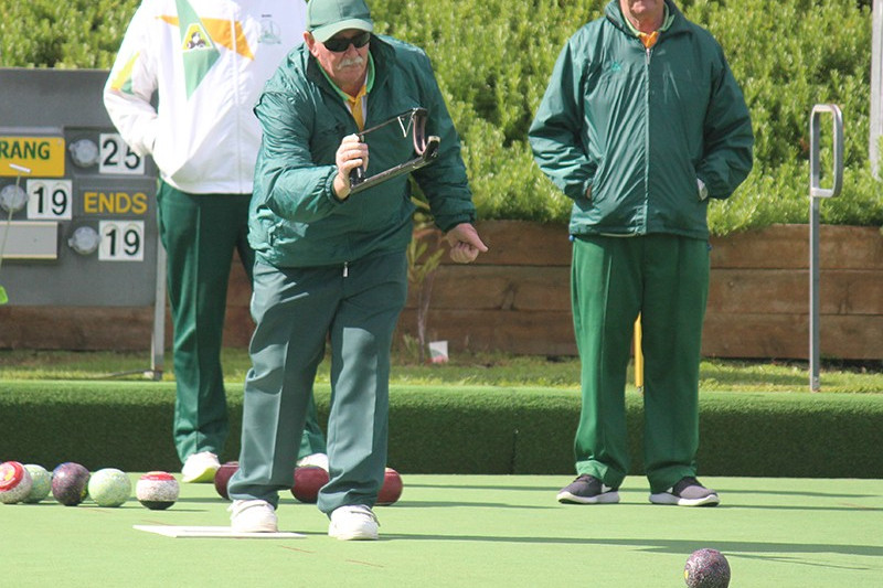 Terang bowlers Barry Stonehouse (back left) and Terry Heffernan (back right) watch team-mate Jack Fowler send down his bowl during their rink’s win against Timboon Gold last Saturday.