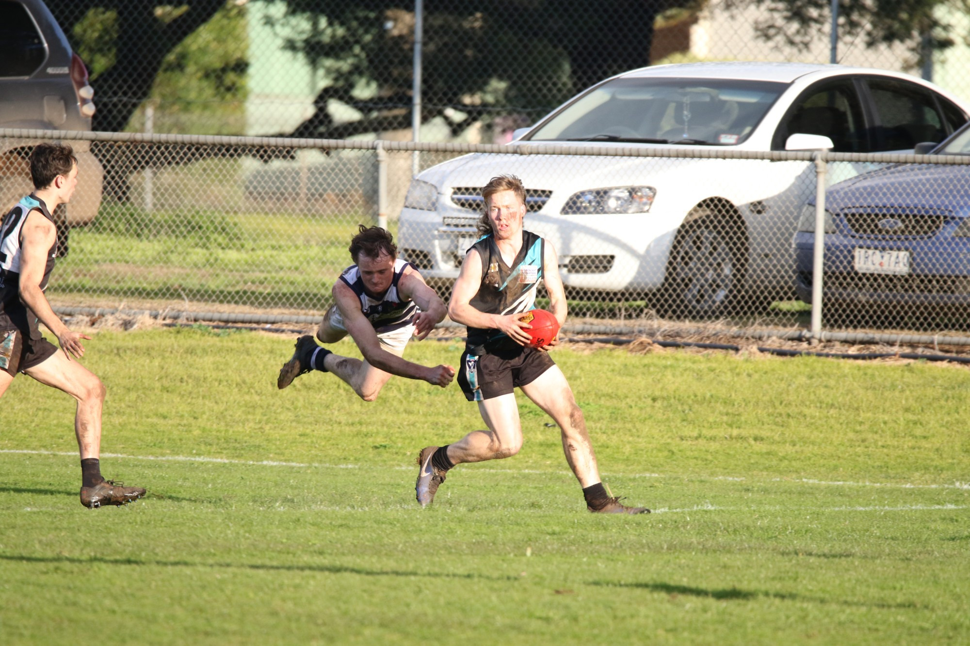 Searching downfield: Kolora Noorat’s Jacon Brookes looks downfield for a team-mate after working hard to free himself from his Allansford opponent.