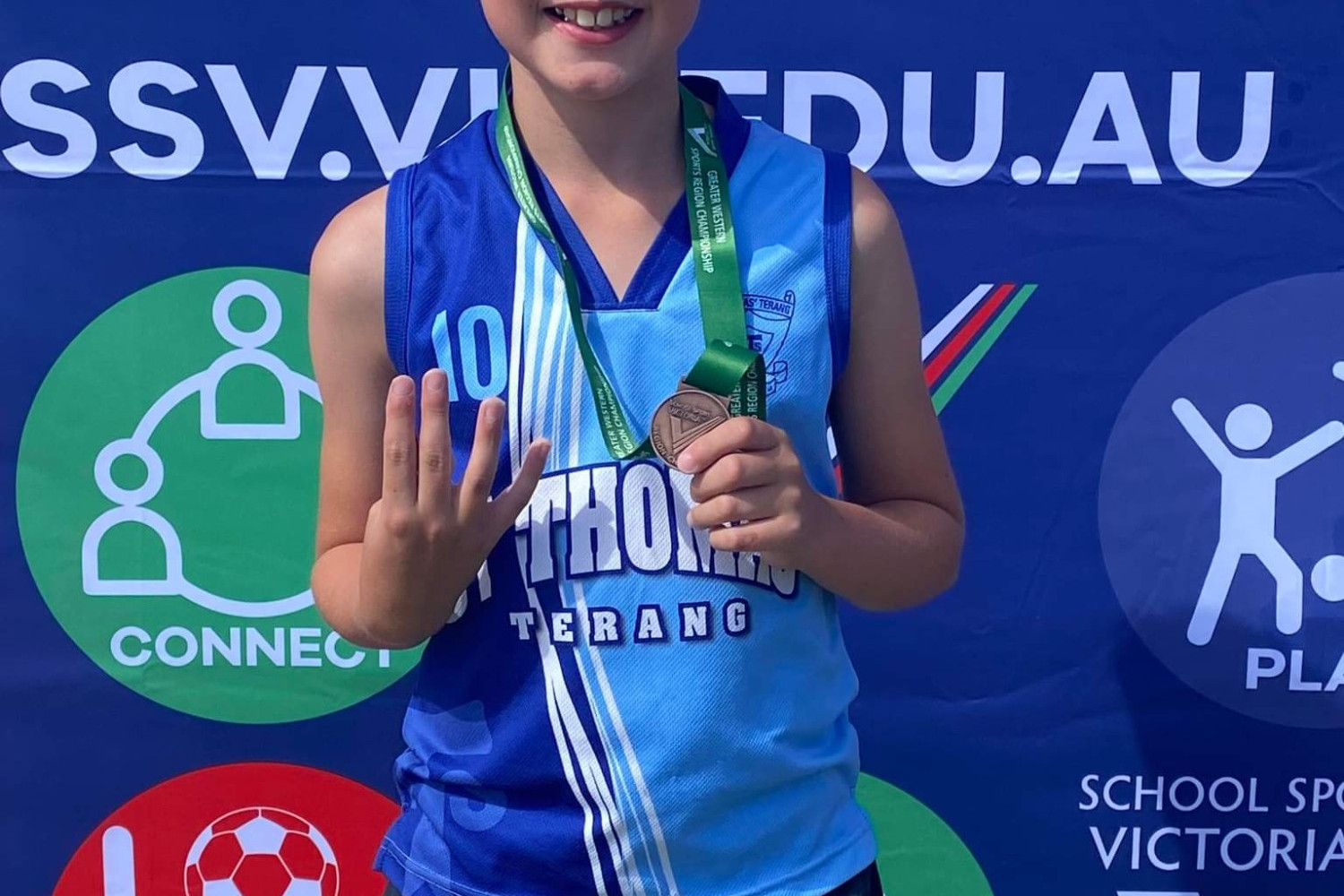 Right: Daniel Hyatt proudly displays his bronze medal for his swim in the butterfly.