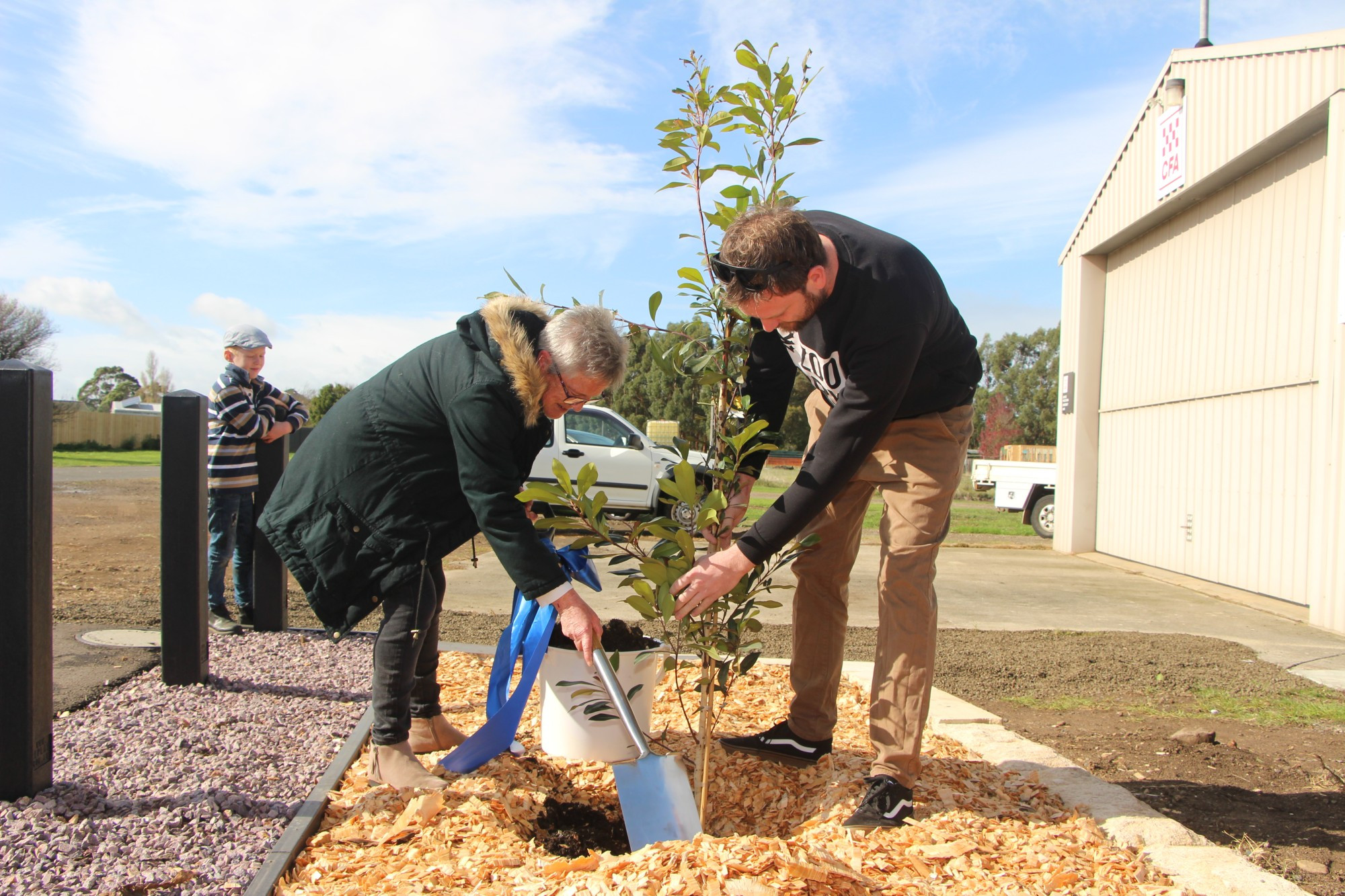 Garvoc’s gift to Leo: Diane Campbell was joined by members of her family to plant a memorial tree in tribute to her late husband, Leo.