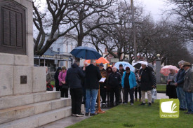 Solemn: Members of the community braved the elements to pay their respects. 