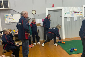 In Division 3, Peterborough Second Angela Payne delivers her bowl as everyone watches on. 