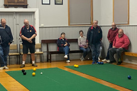 In Division 1 (left), Scotts Creek 1 Skip Allen Armistead and Glenormiston 1 Skip Ron Heard watch their match unfold on their mat as Timboon Lawn 5 Third Jim Mungean (right) bowls his second bowl. 