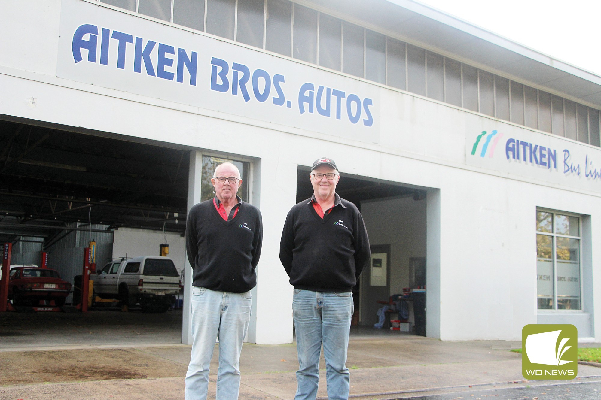 Ready for retirement: Bill and Mark Aitken, pictured with the first bus they added to their fleet more than 20 years ago, have made the decision to retire.