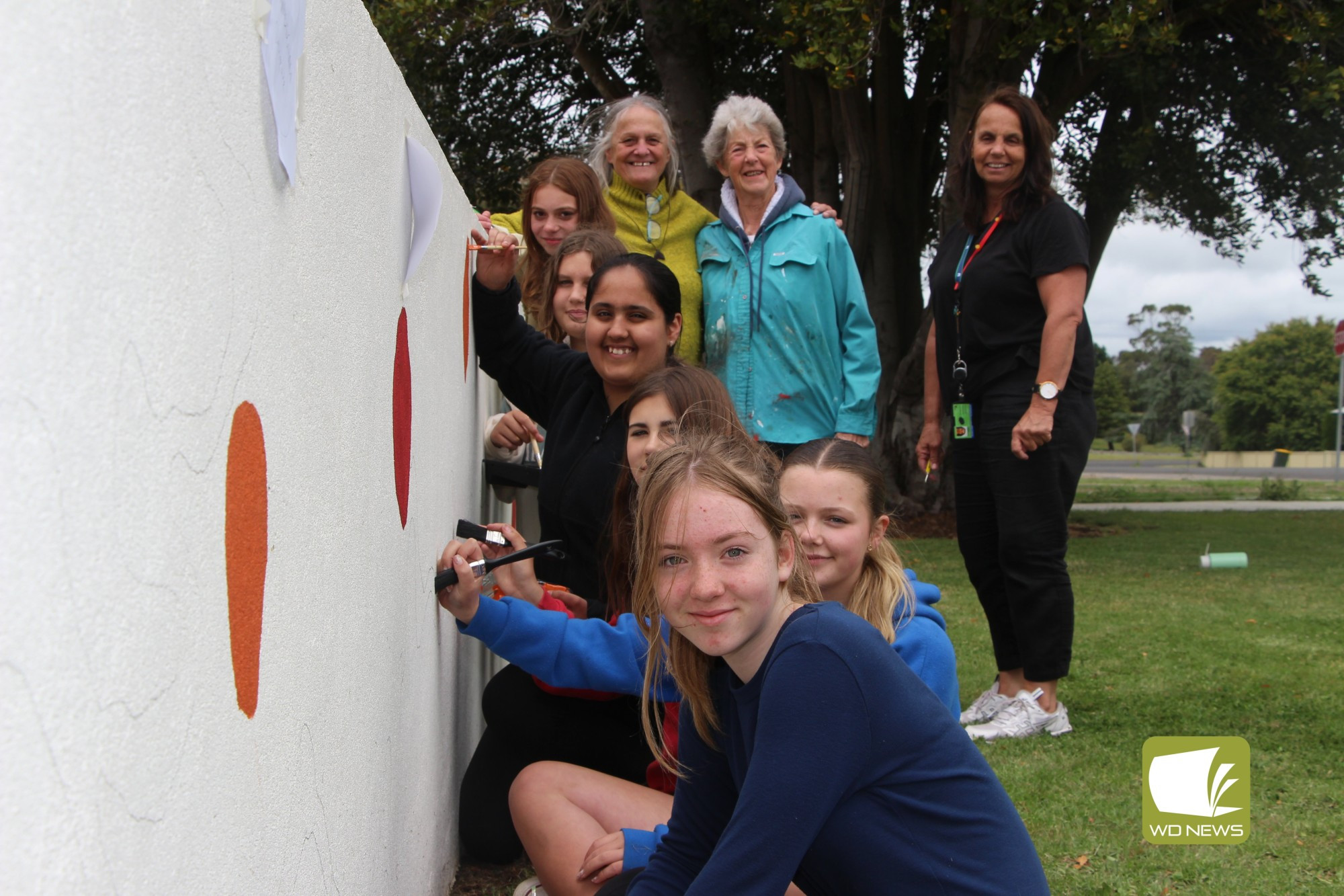 Storytelling: Dr Vicki Couzens, Margaret Moloney and Lisa Couzens joined Terang College students last week to paint a new mural at the school entrance which the students have designed.