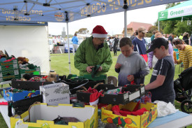 Marilyn Kimber helps youngsters dress their stuffed toys at the Rotary Club of Cobden stand. 