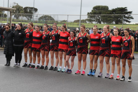 Cobden’s open netballers stand united for the national anthem prior to Saturday’s grand final at Warrnambool’s Reid Oval.