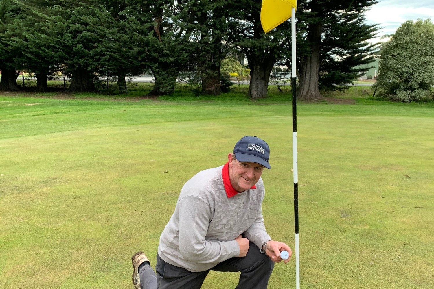 Cobden’s Ulbe Twynstra collects his ball from the cup of the fourth hole following his hole-in-one on Saturday.