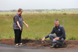 Paula Poole and Andrew Chivell stand in a large pothole which continues to crumble away. 