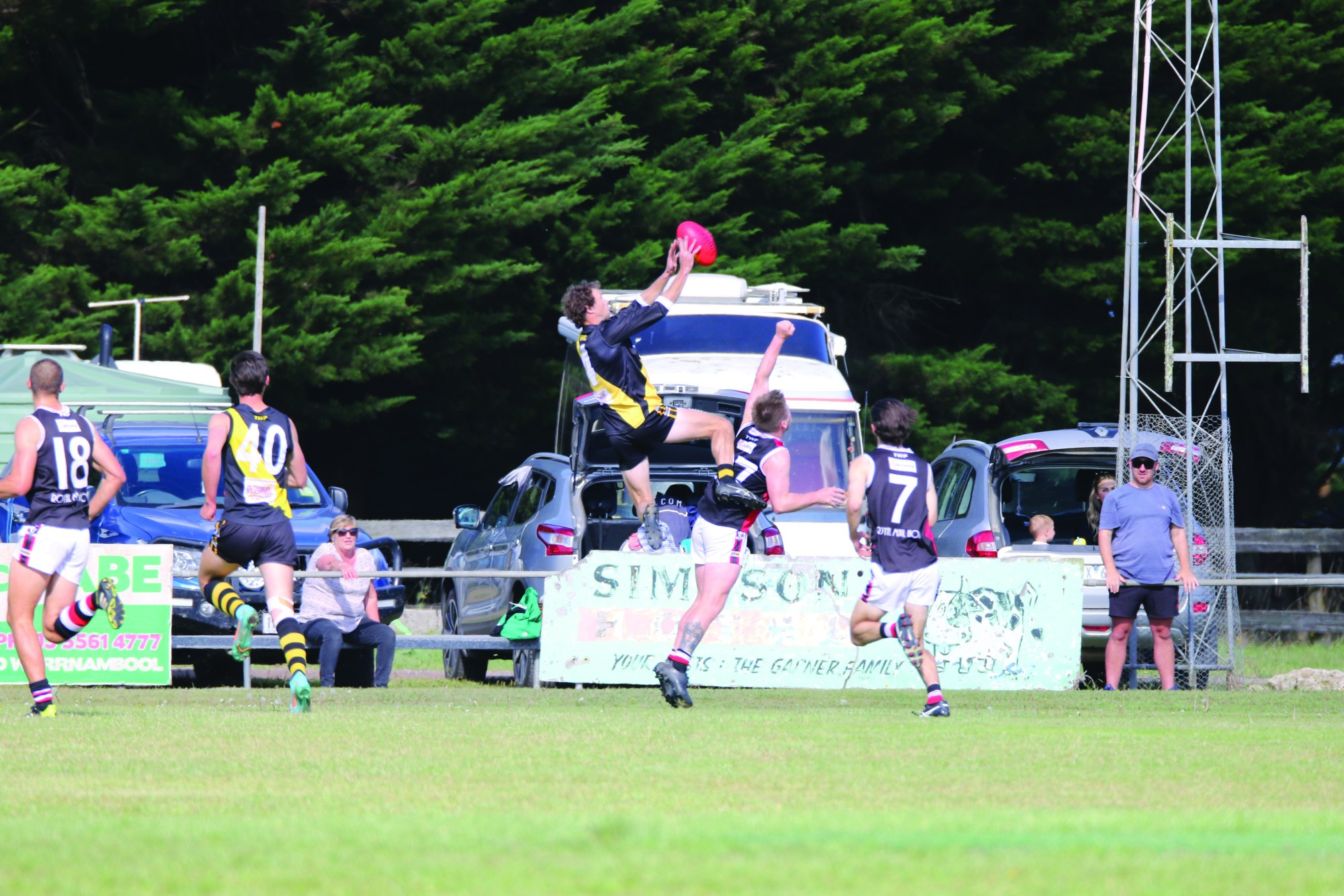 Flying HIgh: Brenton de Jong flies as Simpson wins its third straight to top the Colac and District Football League ladder.