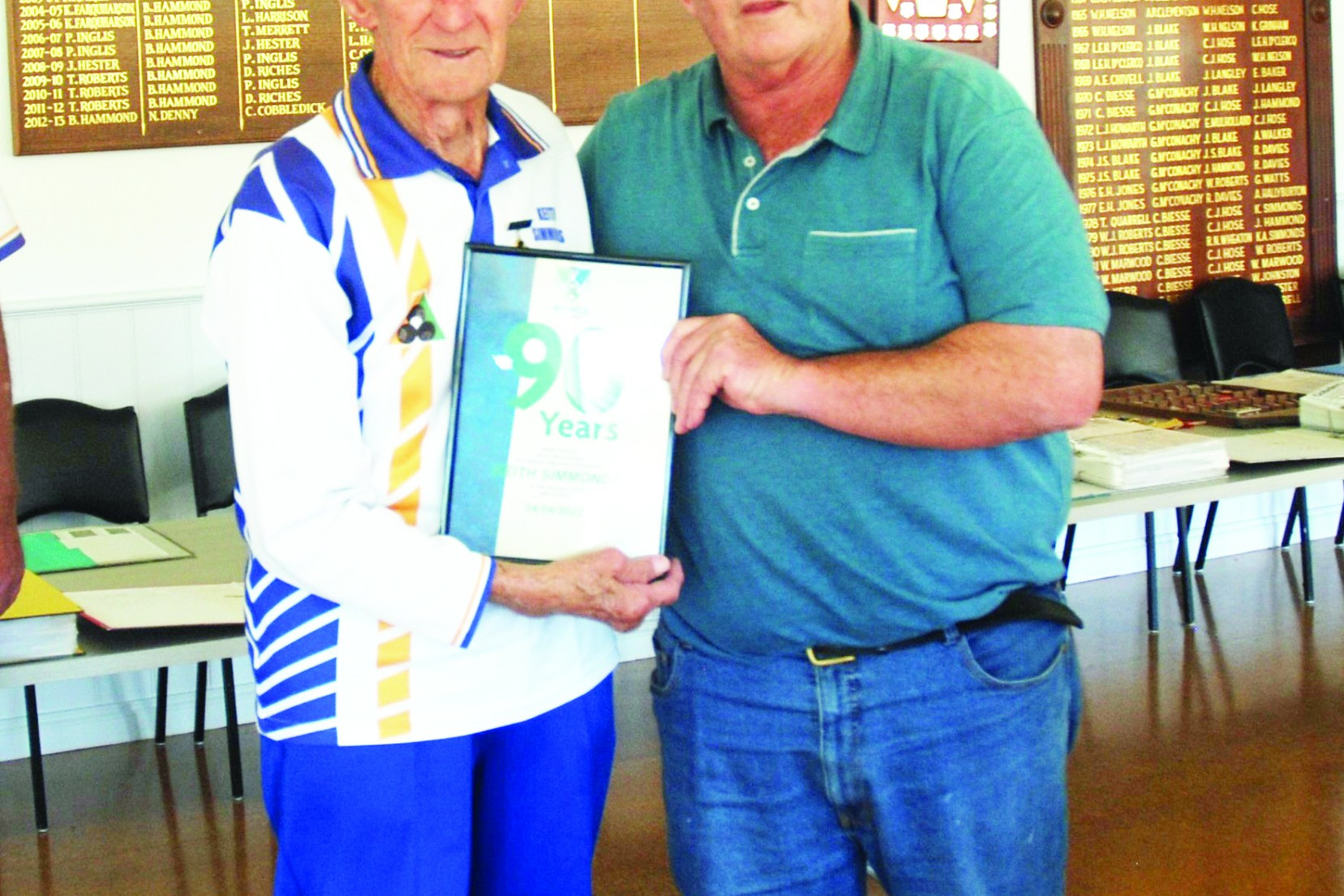 Bowls Victoria president Peter Inglis presents life member Keith Simmonds with a certificate and badge to celebrate reaching his 90th year.
