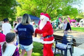 Santa hands out lollies to youngsters. 