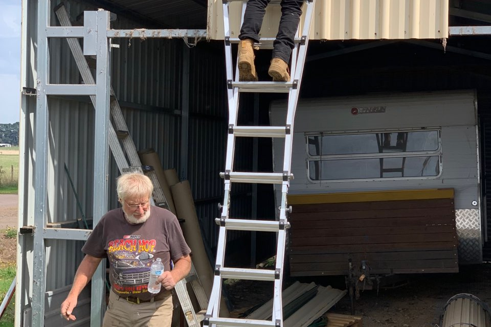 Grant success: Contractor Leigh Podger helps extend the Cobden Rotary Club’s caravan shed, with help from Rotary member Neil Podger.