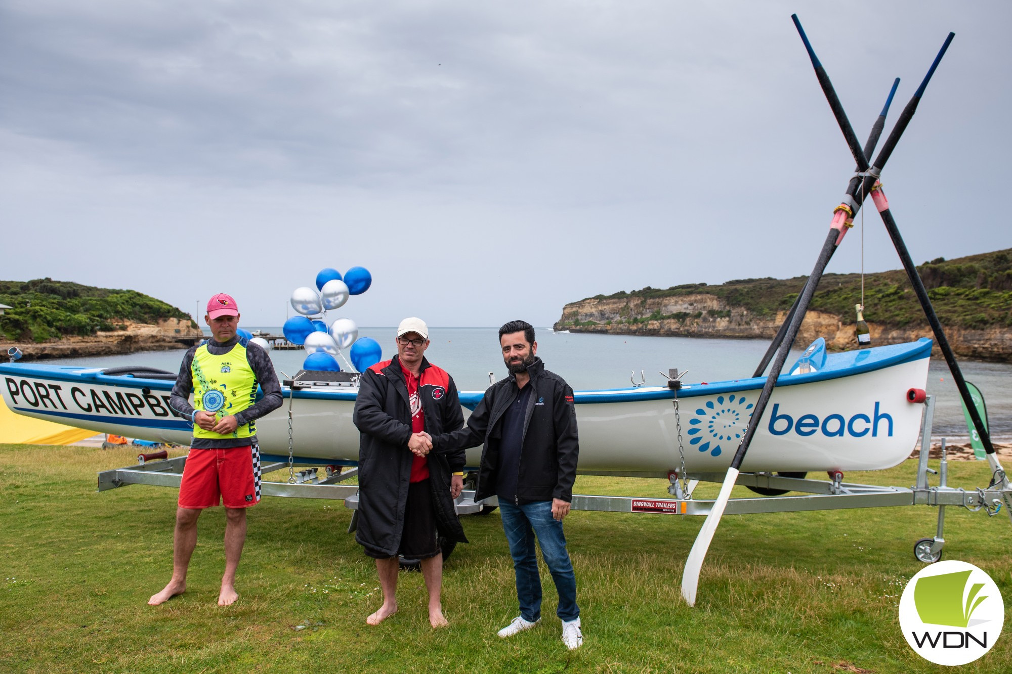 Partnership: Port Campbell Surf Life Saving Club boat captain Andrew Vogels and club president Scott McKenzie with Beach Energy Otway Gas Plant production manager Kevin Galea launch the club’s new surf boat on the weekend.