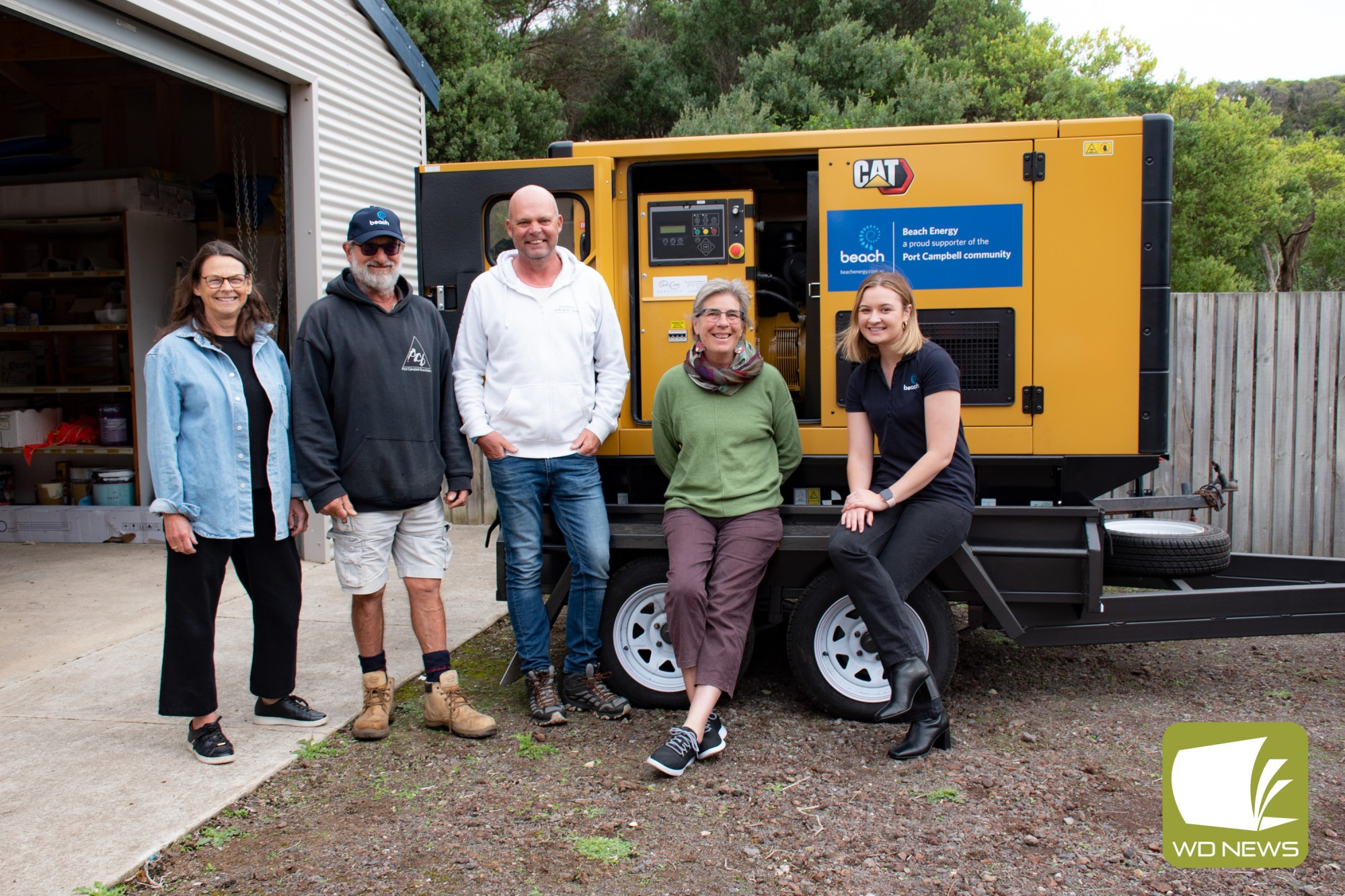 Generator arrives: Members of Port Campbell Progress Group and Port Campbell Surf Life Saving Club - Helen Arundel, Phillip Younis, Andrew Vogels, Julie Brazier with Beach Energy stakeholder engagement advisor Emily Messenger in front of the community generator.