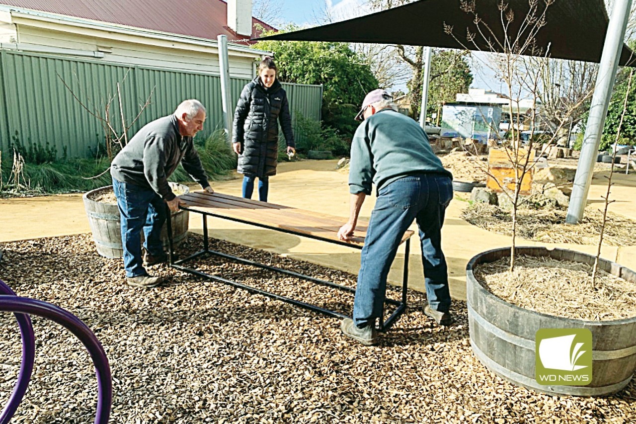 Boost for kinder: Early years educational leader Susan Brown with Cobden Men’s Shed members Colin Munro and Robert Foote install new bench seats at the Cobden Kindergarten.