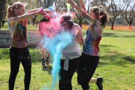 Flying colours: Students also got into the spirit of the event, spraying coloured powder on their peers during the event.