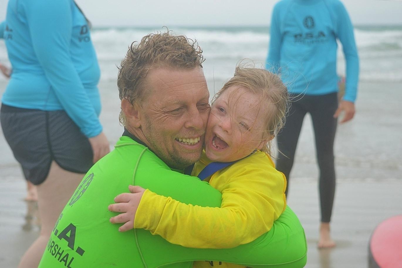 Close friends: Neil Kelly and Adia Herry share an embrace during a successful event for the Disabled Surfers Association.