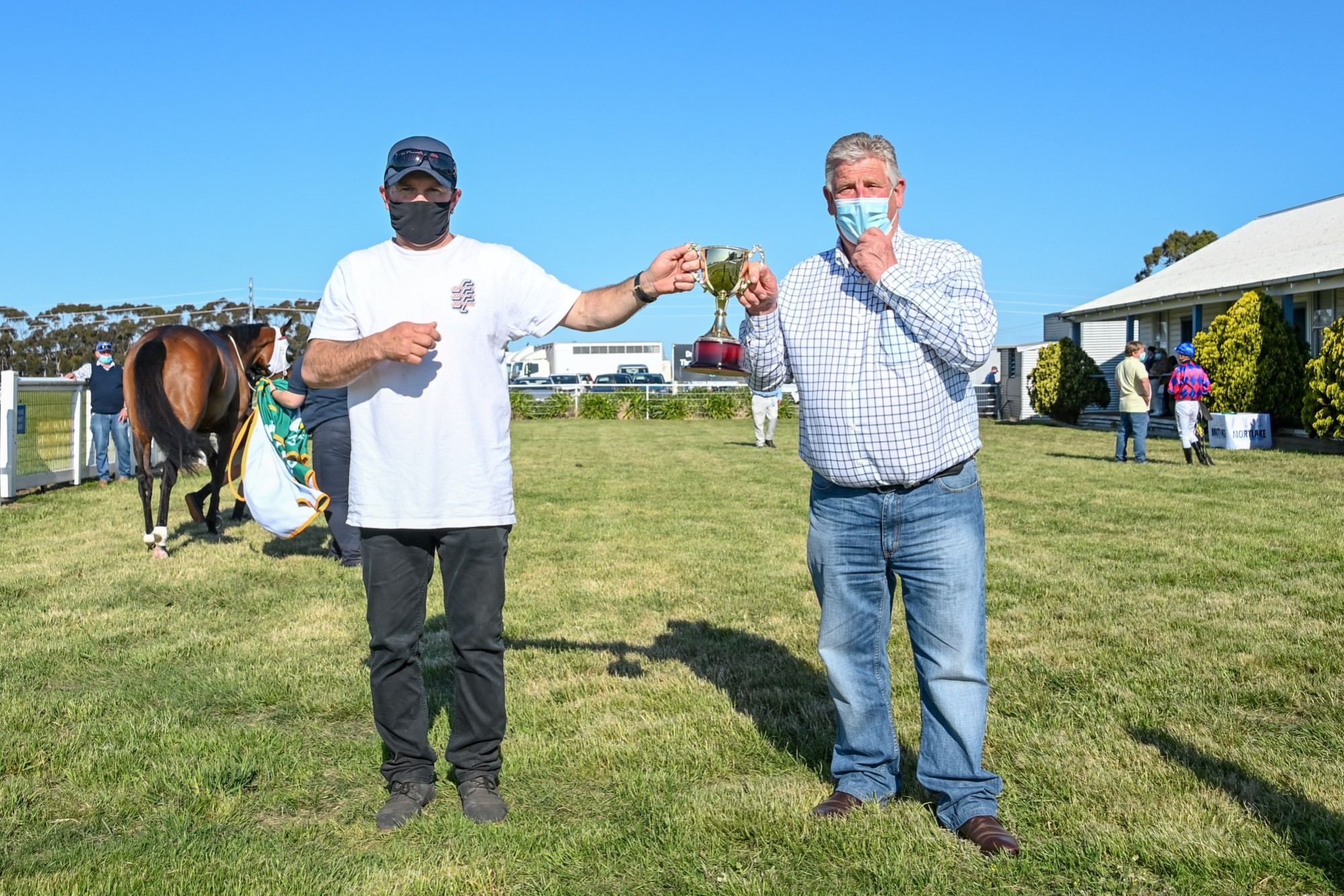 Mortlake Racing Club president Bruce Redpath (right) presents winning trainer Dane Smith with the Mortlake Cup following Robe Bay’s victory. Picture supplied by Alice Miles/Racing Photos