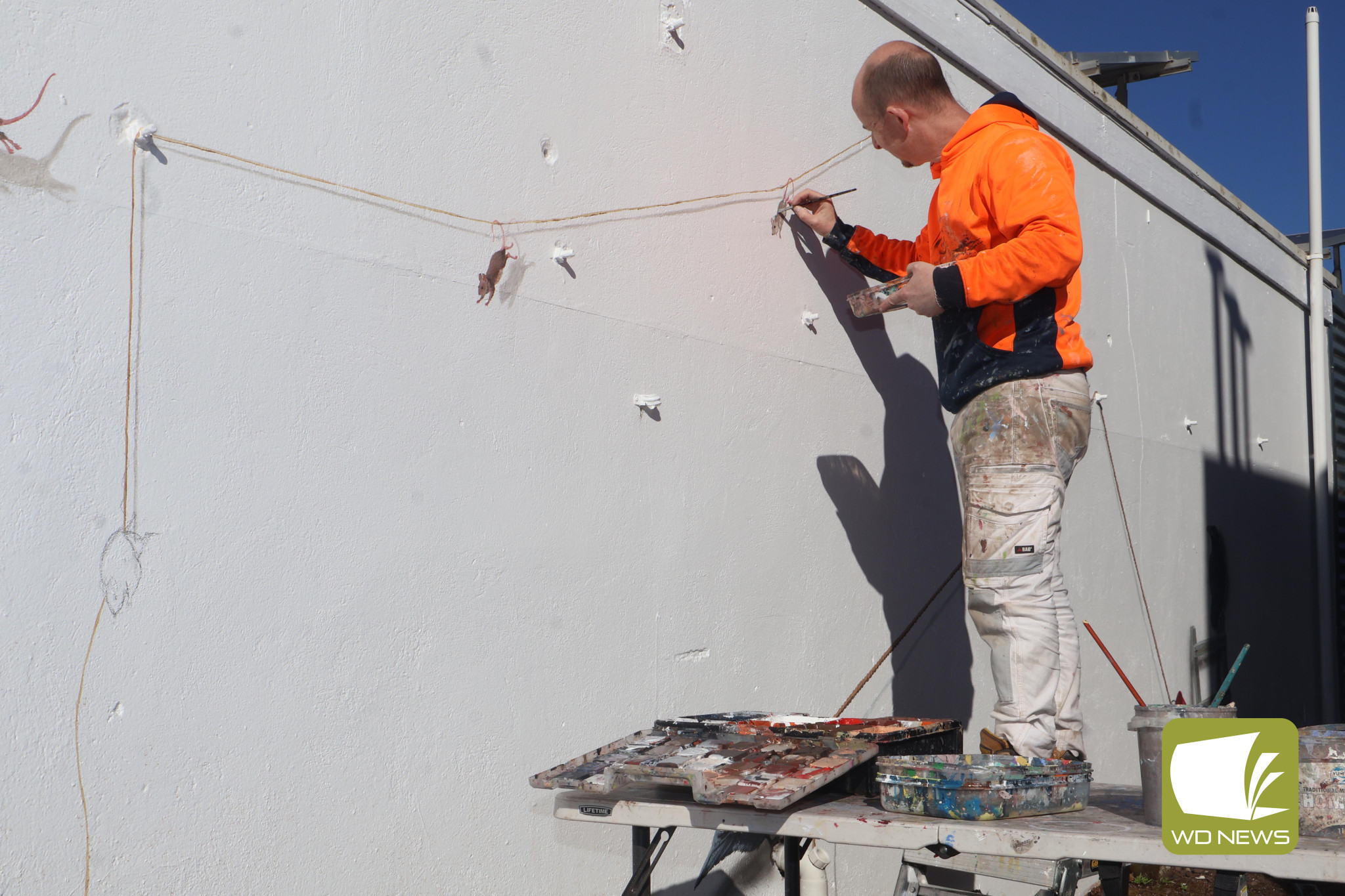 Unfolding: Mr Buscombe began adding further touches to the mural last week.