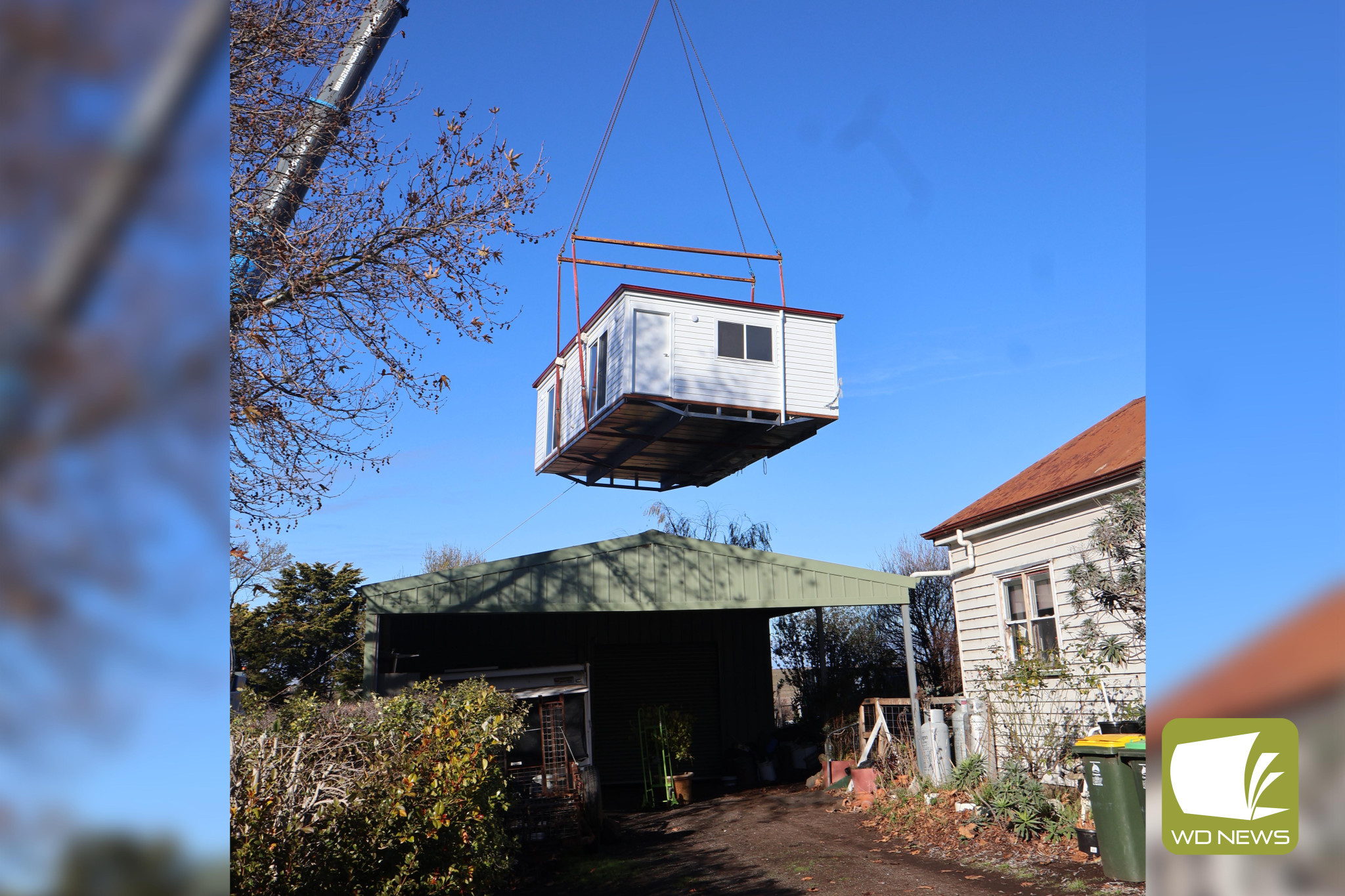 Moving up: Residents of Derrinallum were fascinated by the installation of a detached extension in to a backyard last Friday.