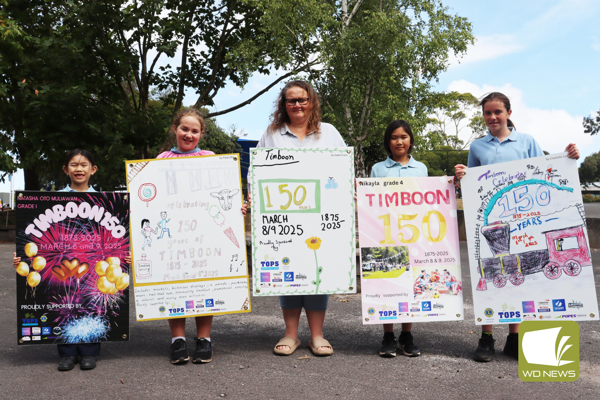 Students celebrate Timboon: Students from Timboon P-12 School posed with posters they designed to promote Timboon’s 150th anniversary.