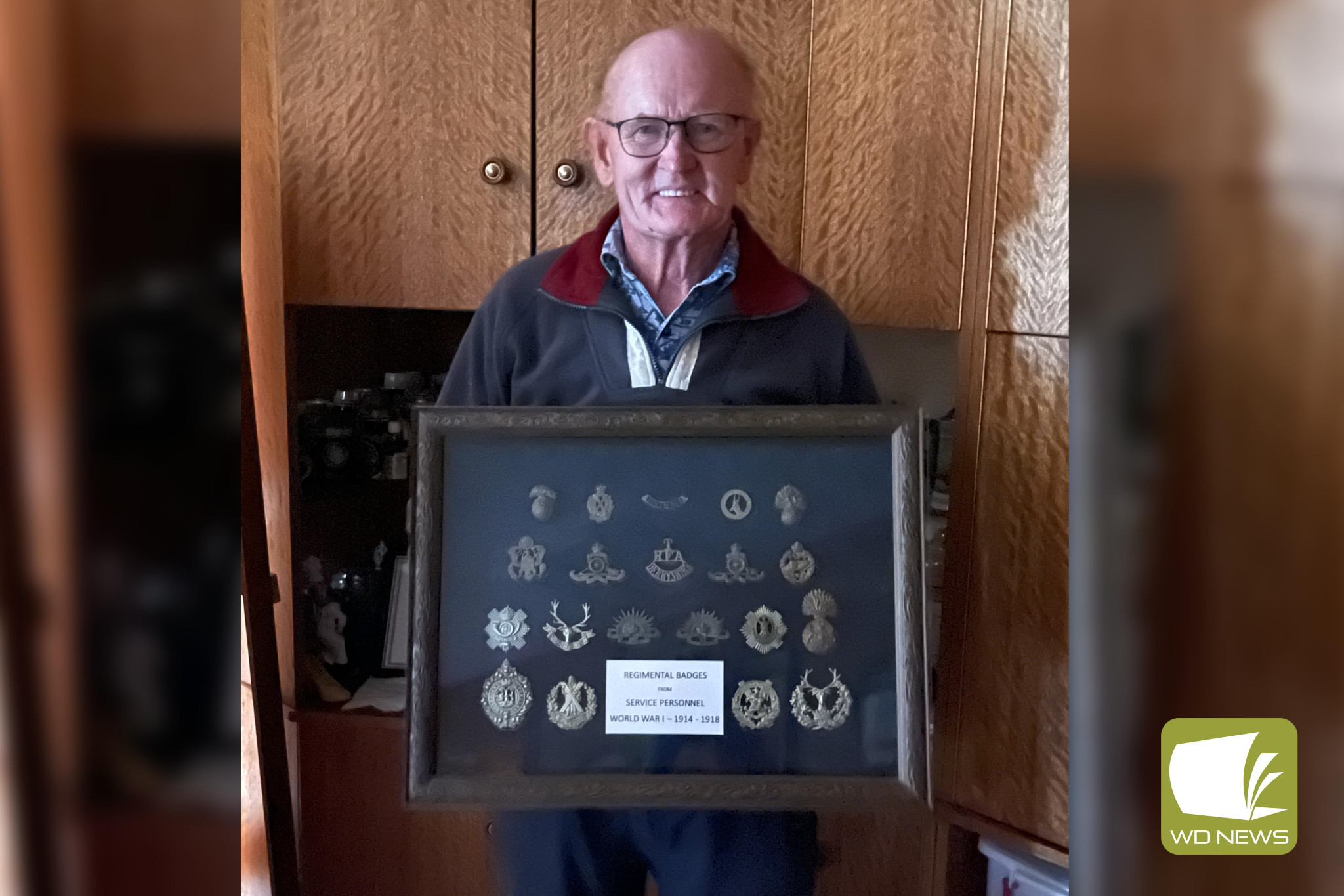 Framed history: Colin Kerr holding the framed display of hat tags which will be available to view at the Cobden Historical Society.