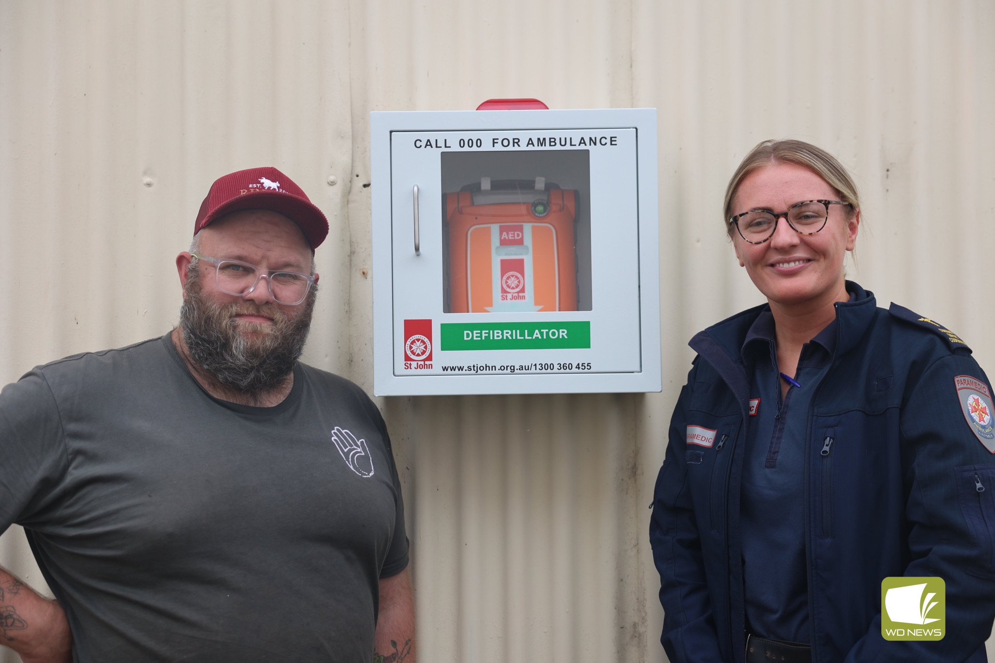 New defibrillator installed: Bush Inn owner Paul Rossiter and paramedic Olivia Glanford with Lismore’s newest defibrillator, located on the side of Mr Rossiter’s store.