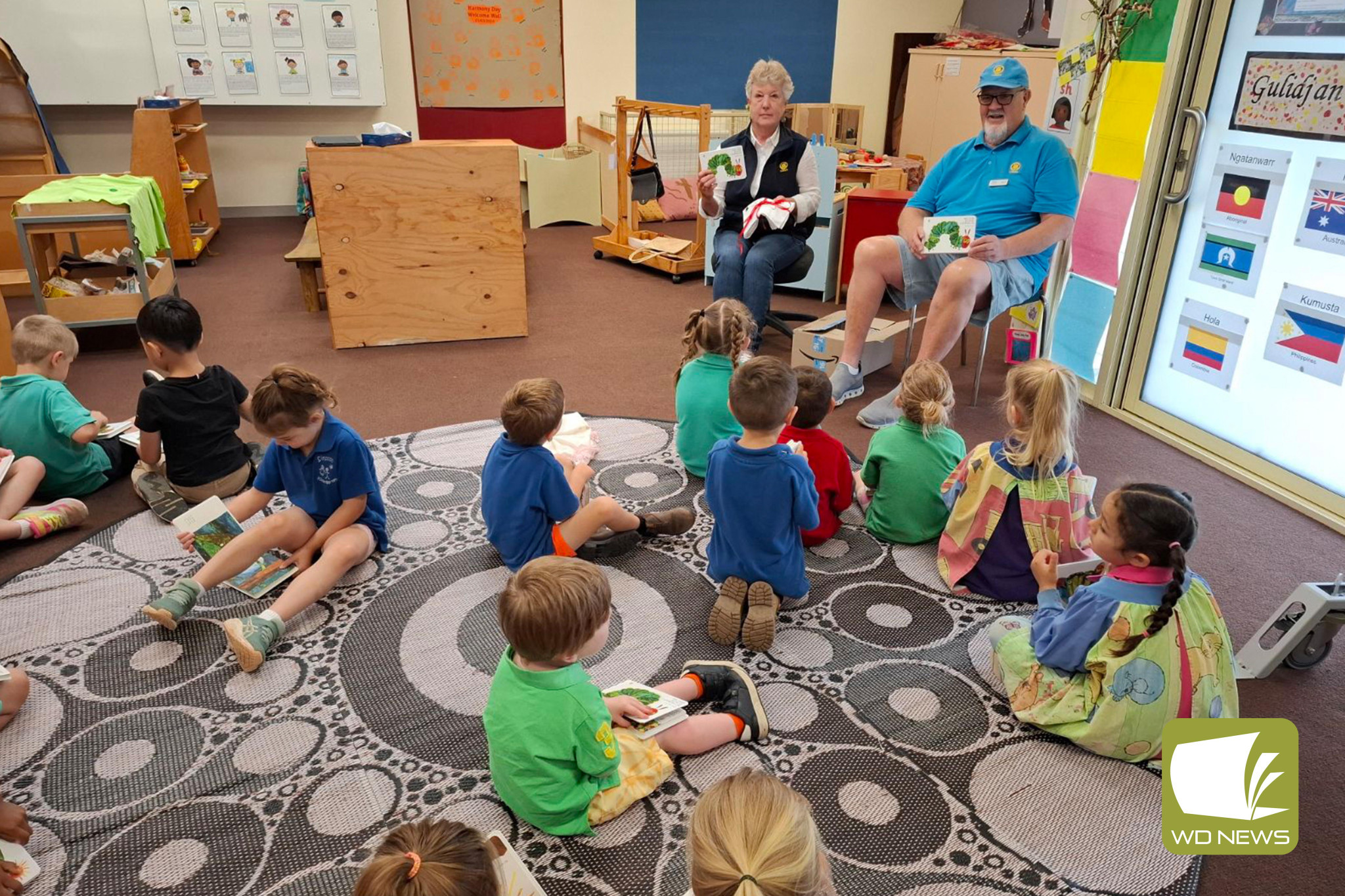 Literacy: Cobden Rotary Club members Lesley Brown and Gary Kimber surprised Simpson Kindergarten children with a new book as part of an ongoing rotary initiative.