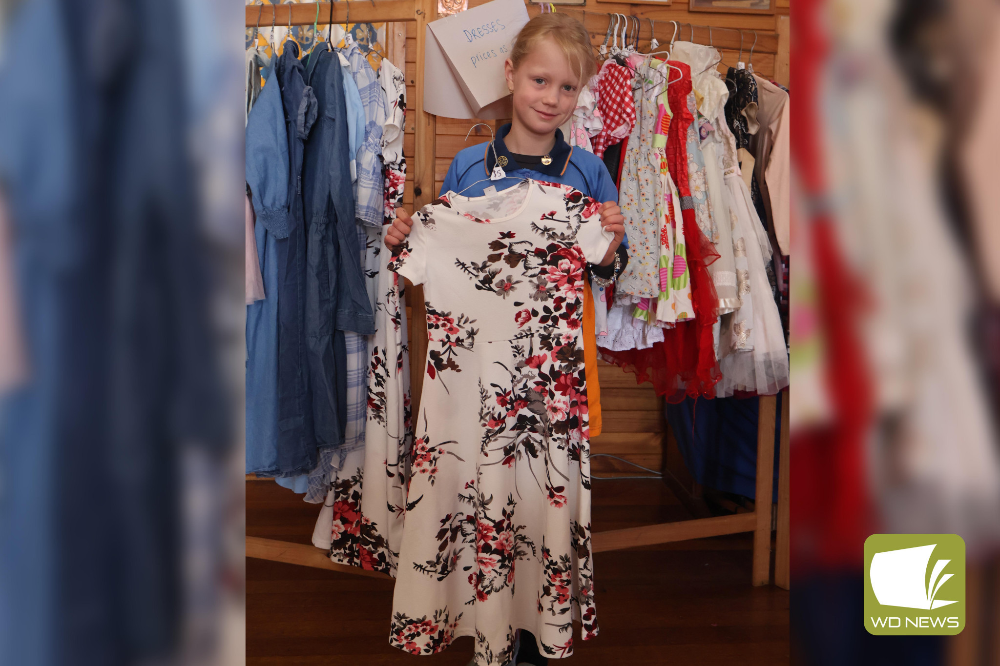 Lovely wares: Girl guide Lexie Lucas with the various dresses that were on sale for the garage sale.