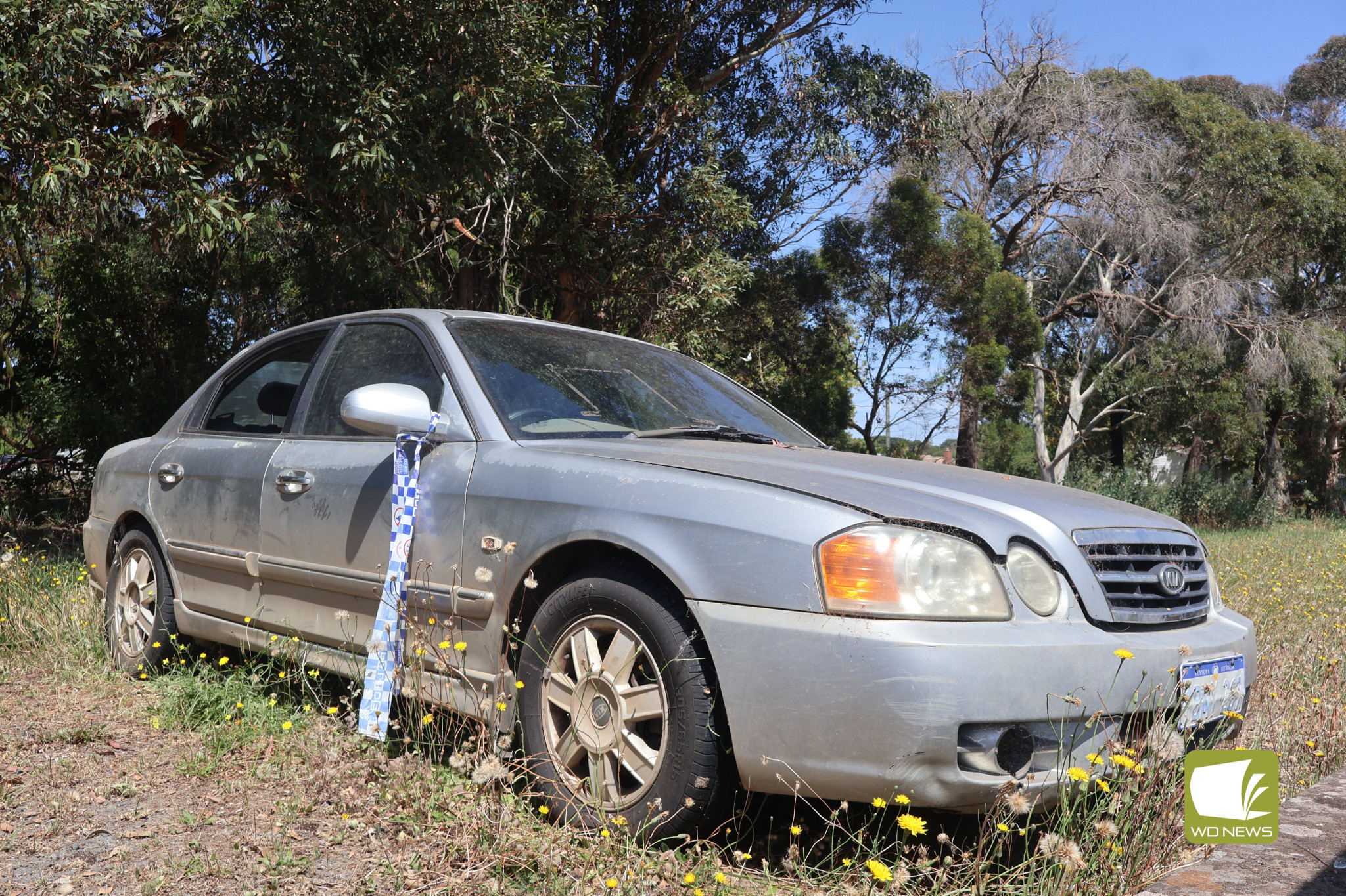 Waiting for removal: A silver Kia Optima with Western Australia license plates and shattered windows has been left dumped at the Terang train station for months.