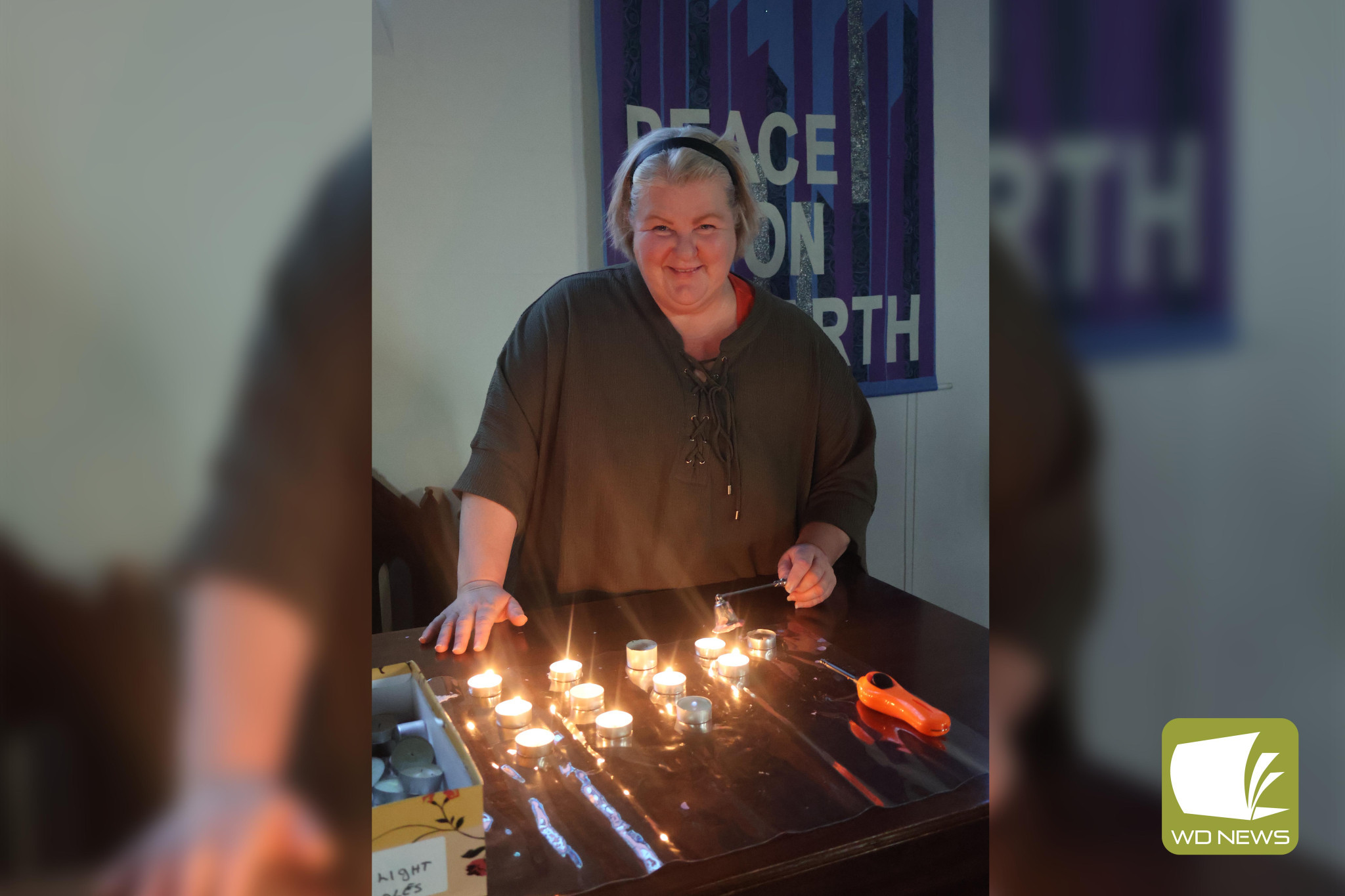 A chance to reflect: Reverend Suzie Castle puts out the flames used as attendees reflected on those lost at a recent Blue Christmas service.