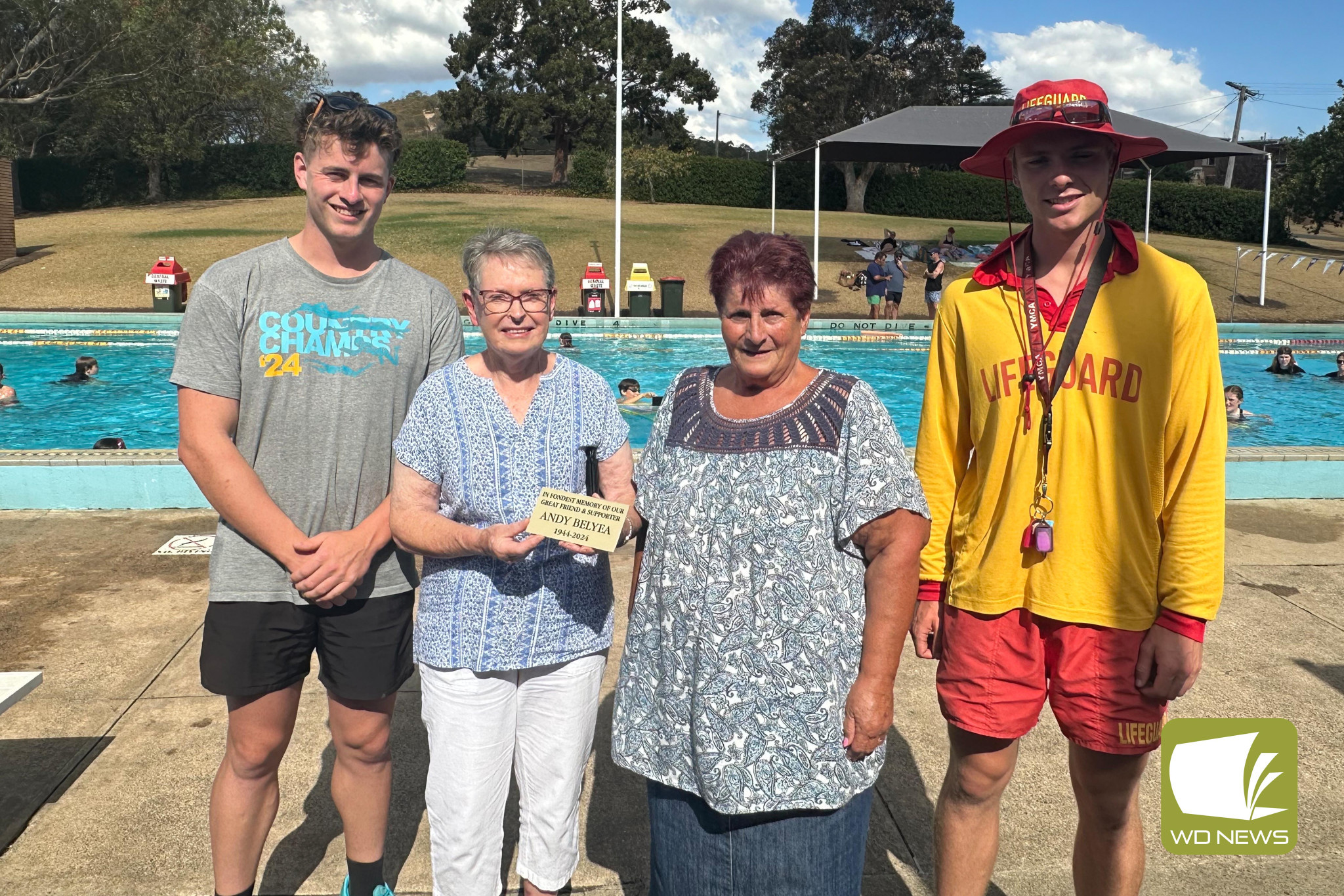 In honour: Maree Belyea (second from left) was presented with a plaque for her late husband’s memorial seat, she is pictured with by William Elliot, Lillian Cronin, and lifeguard Rory.