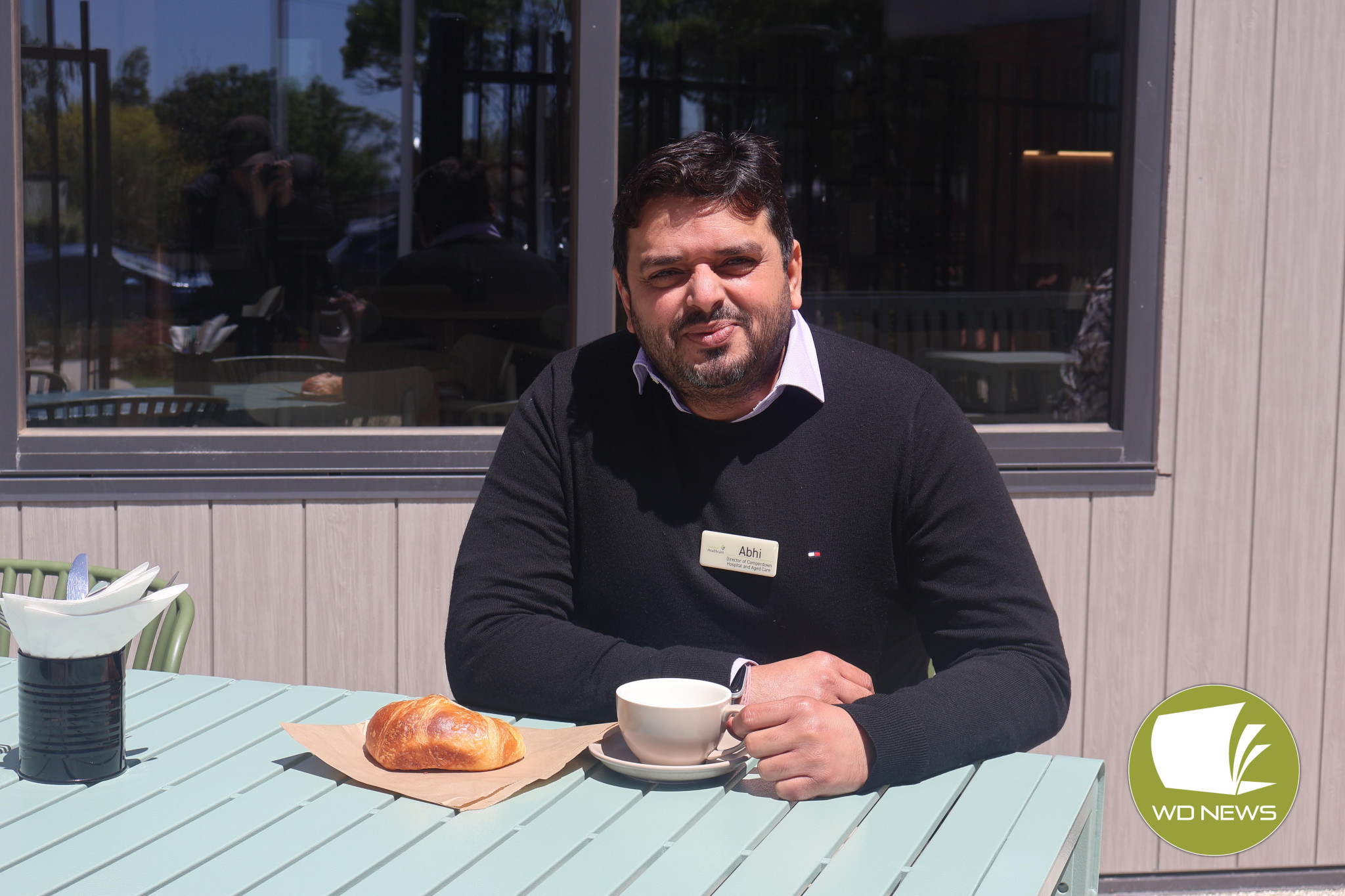 Open for all: South West Healthcare director of Camperdown Hospital and Aged Care Services Abhinay Dolar enjoying a coffee and a croissant at Leura Aged Care’s Sugarloaf Café.