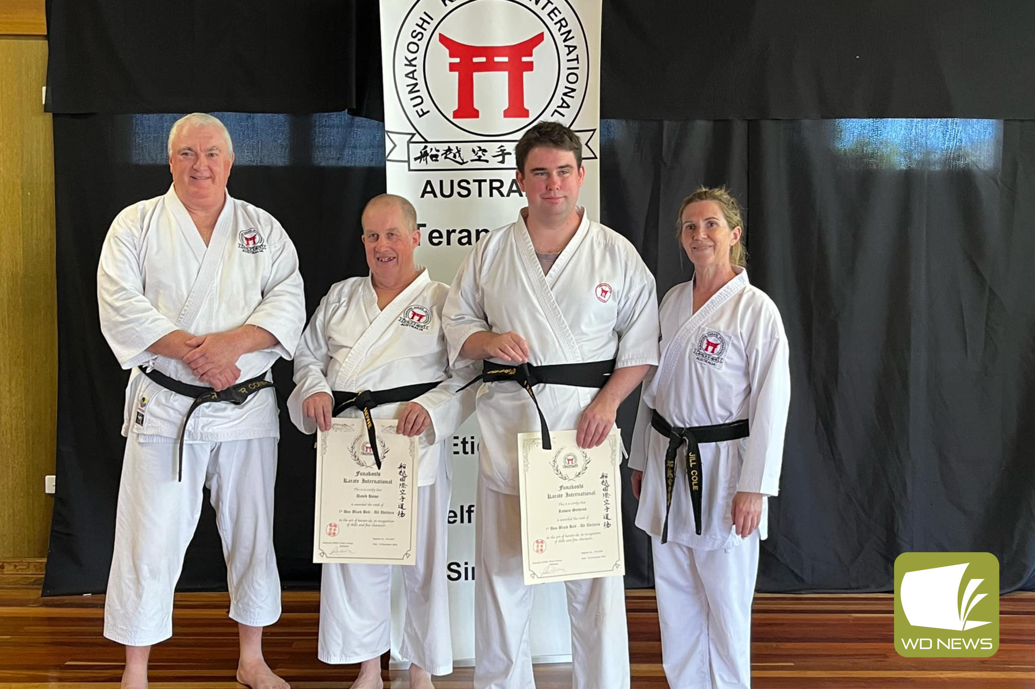 Cooinda’s David Howe and Rowan Stevens are congratulated on receiving their black belts by Peter Conroy and Jill Cole.